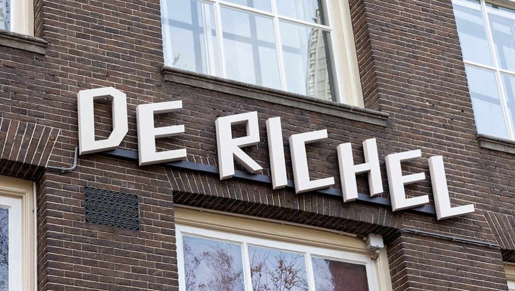 Witte doosletters tegen bakstenen gevel theater De Richel Nieuwezijds Voorburgwal