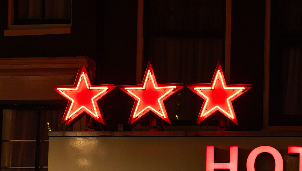 Hotelsterren drie rode neon sterren aan hotel Prins Hendrik in Amsterdam