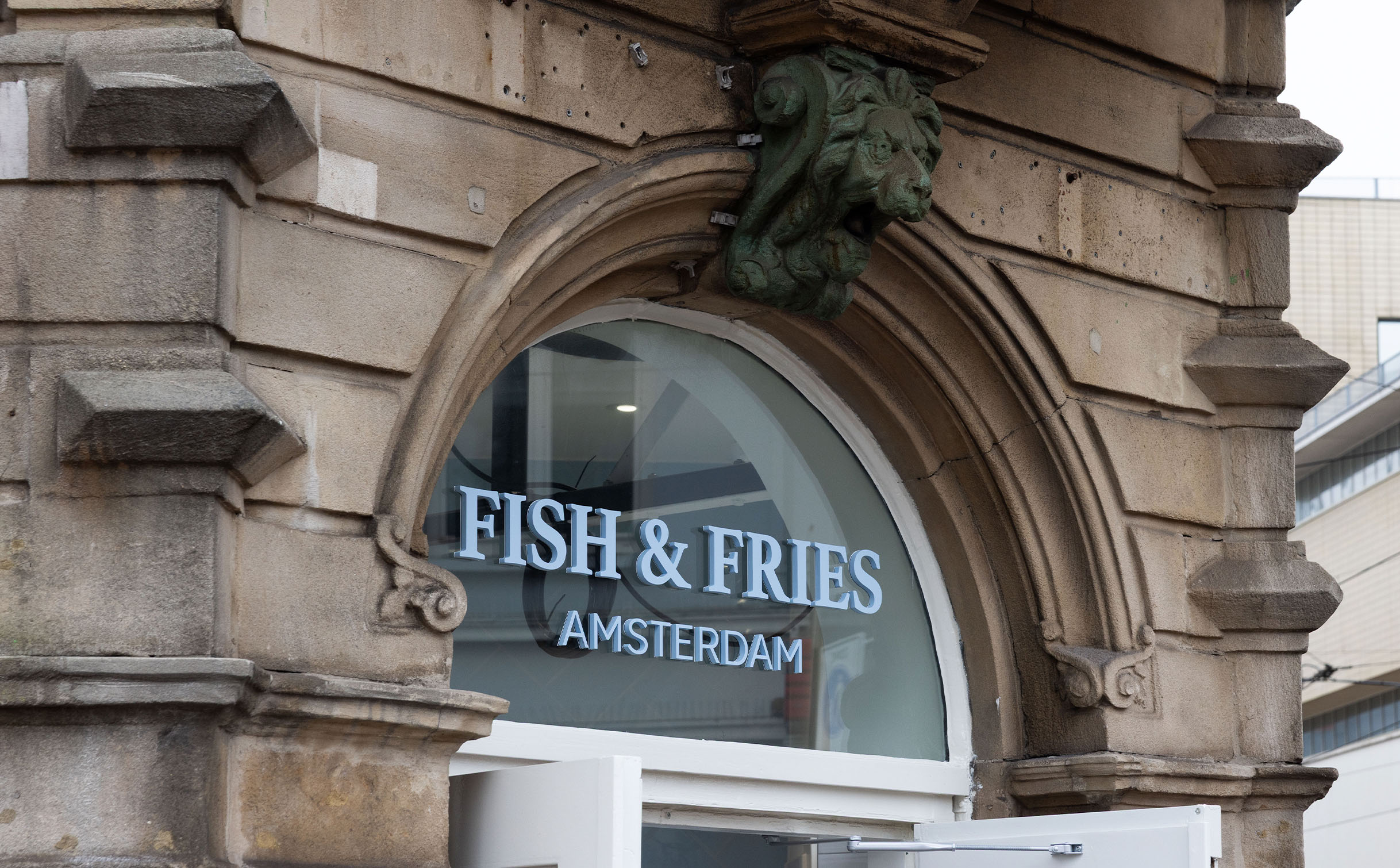 Blauwe freesletters op gevel Fish & Fries Amsterdam